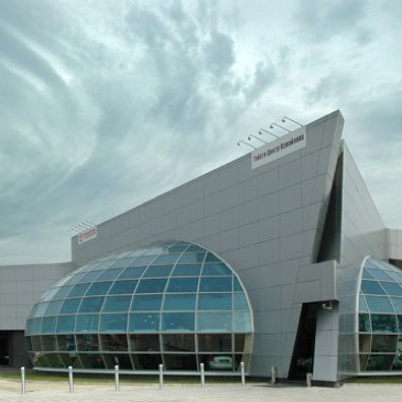 Auf dem Bild ist das Toyota Gebäude in Moskau zu sehen. Ein graues glattes Gebäude aus dem zwei ovale Fensterfronten herausstehen