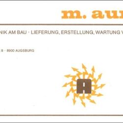 Auf dem Bild ist das Logo der Michael Aumüller KG von 1972 bis 1980 zu sehen mit orangen Namen und viel Text zu Leistungen und Anschrift