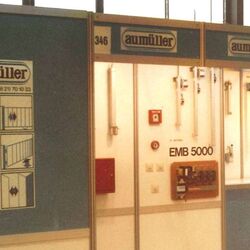 Auf dem Bild ist ein AUMUELLLER Messetand aus dem Jahr 1982 zu sehen der die EMB5000 RWA Zentrale vorstellt
